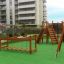 Parco giochi per bambini con strutture da arrampicata in legno, un ponte e uno scivolo in un'area urbana, Chain