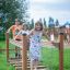 Bambini che giocano sull'attrezzatura da gioco in legno Chain Bridge.