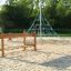 Attrezzatura da parco giochi per bambini Chain Bridge con corde e strutture in legno su una superficie sabbiosa