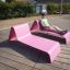 Uomo che si rilassa su un Lounge Sofa rosa all'aperto.