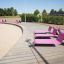Sedie Lounge Sofa rosa su una passerella vicino alla spiaggia.