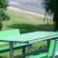 Table HPL verde con panche verdi in un contesto di parco.