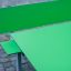 Table HPL verde con configurazione di panca verde abbinata su pavimentazione in ciottoli.