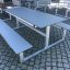 Table & Bench HPL per esterni posizionato su una superficie in ciottoli.