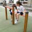 Due ragazze che giocano sulle barre fitness Somersault Double in un parco giochi.