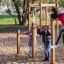 Bambini che giocano su attrezzatura da gioco Somersault Triple in un parco