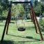 Altalena con pneumatico in una struttura in legno Single swing in un parco verde