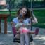 Madre e bambino seduti insieme su Safety Seat Single Swing nell’area giochi.