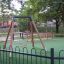 Safety Seat Single Swing in un parco giochi con erba sintetica verde