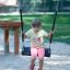 Bambino seduto su Safety Seat Single Swing in un’area giochi
