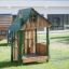 Struttura da gioco in legno Nill's Playhouse per bambini in un parco giochi erboso