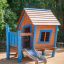 Casetta da gioco in legno Olle's Playhouse con dettagli blu e scivolo in un parco giochi