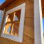 Lisa's Playhouse with slide realizzato in legno con un primo piano della cornice di una finestra.