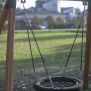 Altalena singola Single Swing (BNS 90cm) con sedile rotondo intrecciato e struttura in legno e metallo.
