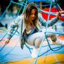 Ragazza che gioca sulla rete da arrampicata Powerclimber climbing net in area giochi.