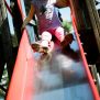 Bambina che scende da scivolo rosso dell'Activity Center with Slide in area giochi.